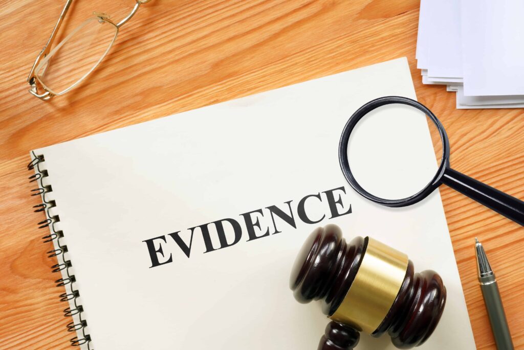 Legal evidence folder with gavel and magnifying glass on desk. Legal evidence folder with gavel and magnifying glass on desk.